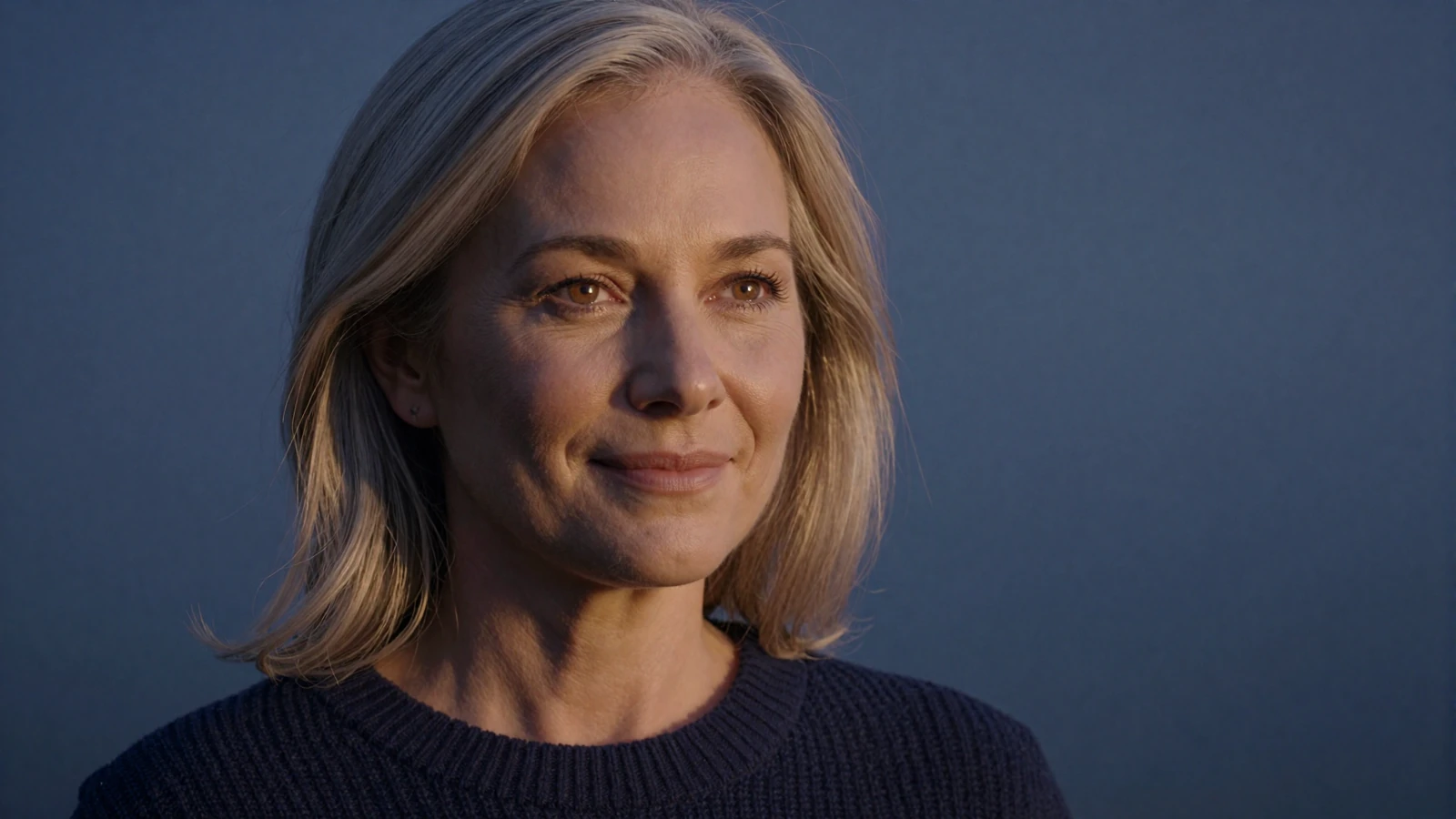 Serene mature woman in her mid-fifties with a calm, confident expression on a twilight backdrop, reflecting the trust of a safe dating site